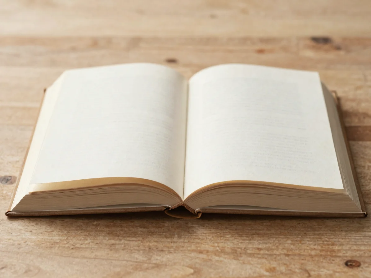 Editorial close-up of an open hardback on a wooden table, soft di